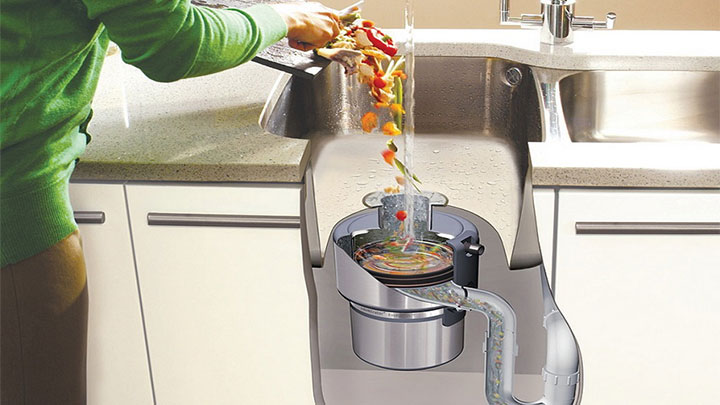 This is an image of a person scraping off food from a plate in to the sink to show proper garbage disposal maintenance