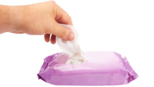 Image of a hand pulling a wet wipe out of the container used for the article How Should I Dispose of Wet Wipes
